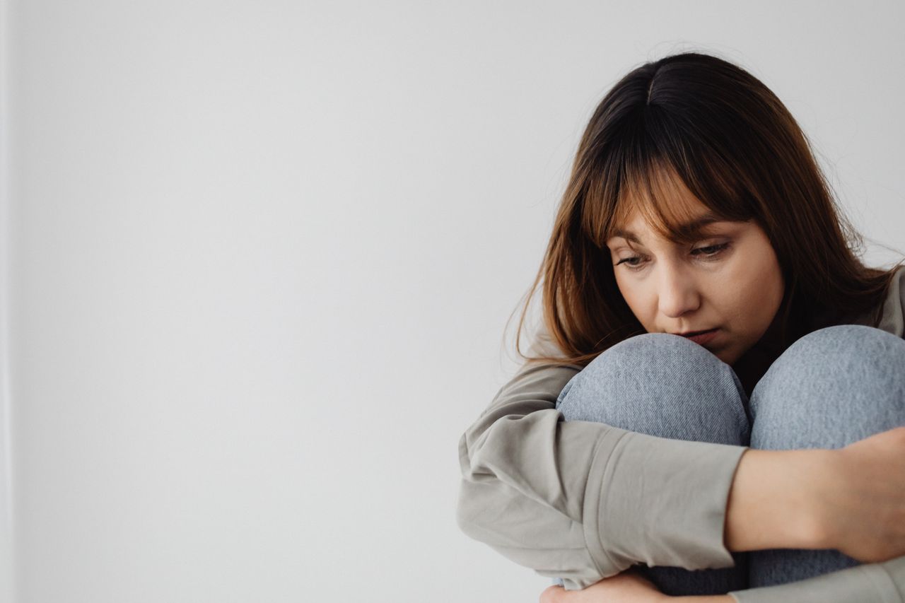 A warm, supportive therapy session between a counselor and a client working through depression