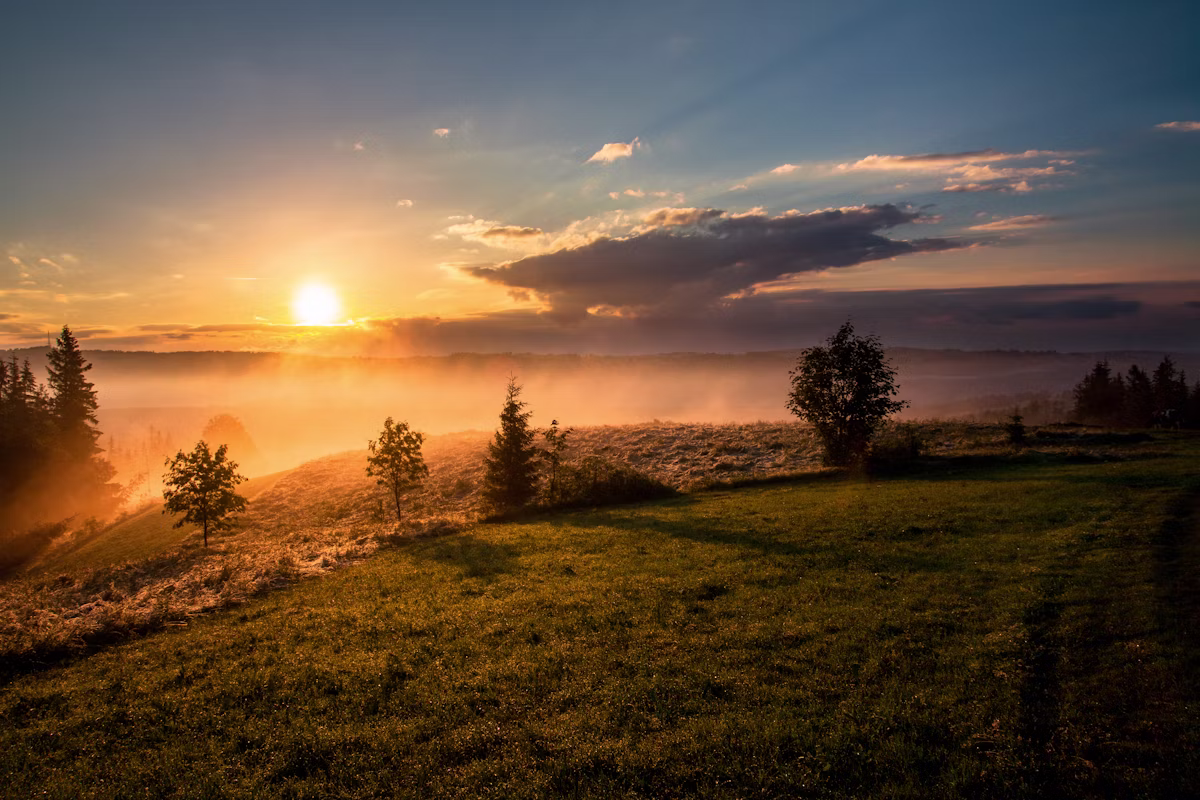 Sunrise over a calm landscape representing a new beginning and hope after trauma