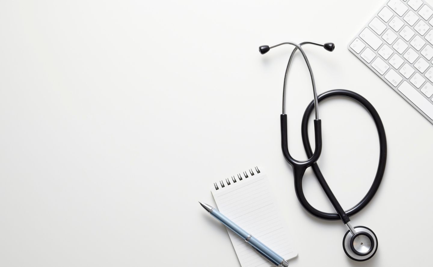 clinical supervisor Yuba City - Every Day Counts Stethoscope, notebook, and pen on a white desk with a portion of a keyboard in the corner, suggesting a medical office workspace.